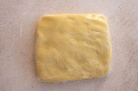 Der Teig ist in Klarsichtfolie eingewickelt.