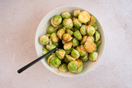 Der Rosenkohl wird mit der asiatischen Marinade vermengt.
