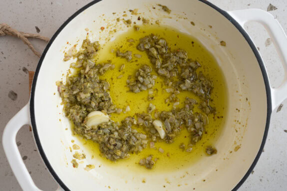 Das Pesto wird zu den Schalotten in die Pfanne gegeben.