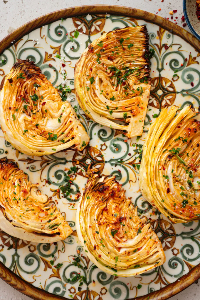 Ein großer Teller mit gerösteten Weißkohl Wedges aus dem Airfryer.