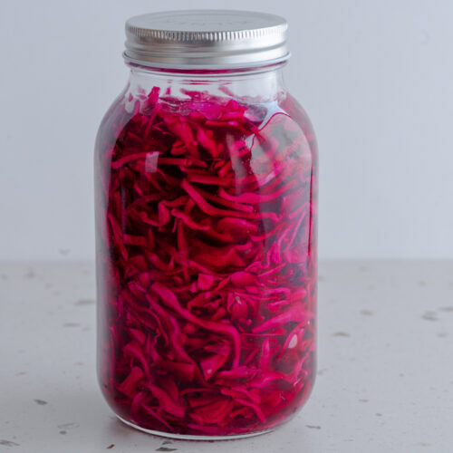 Ein verschlossenes Glas mit eingelegtem Rotkohl steht auf einem Tisch.