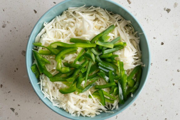 Der rohe Weißkohl und die grüne Paprika sind in einer Schüssel.