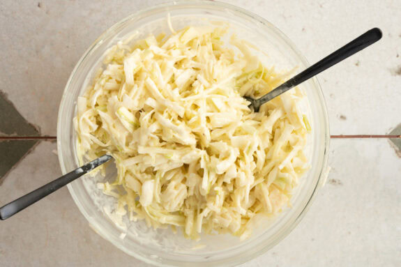 Der Salat wird mit dem Dressing vermengt.