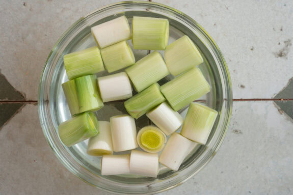 Eine Schüssel voller Wasser in der geschnittener Lauch liegt.