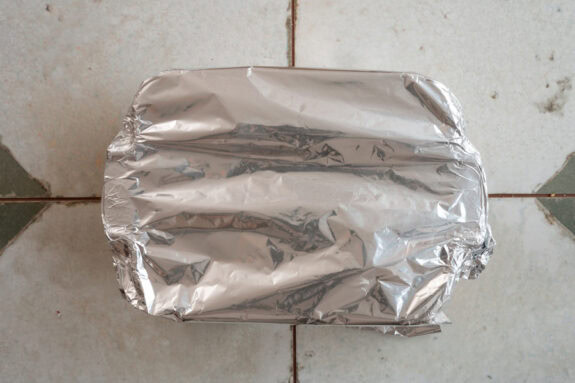 Die Auflaufform wird mit Alufolie bedeckt.