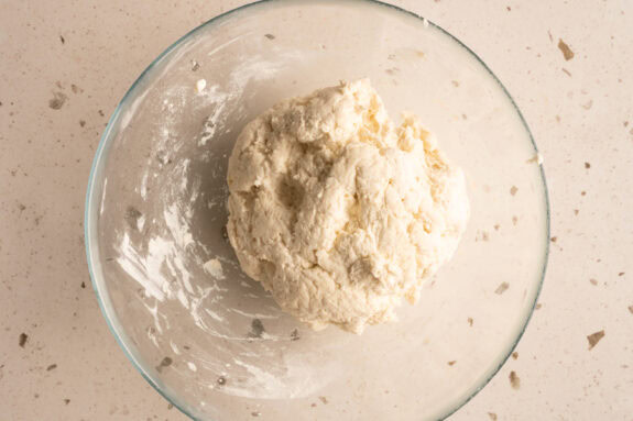 Der fertige Teig für die Brötchen ist in einer Glasschüssel.