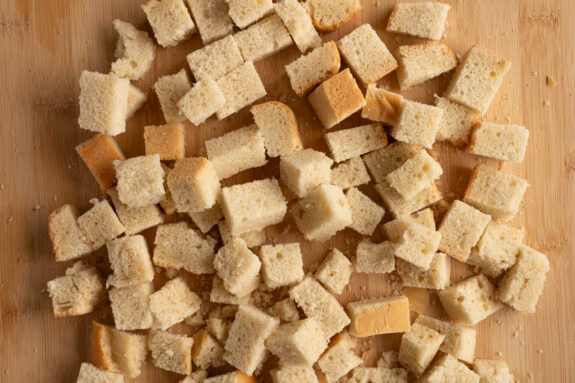 Das Brot liegt in Würfeln geschnitten auf einem Brettchen.