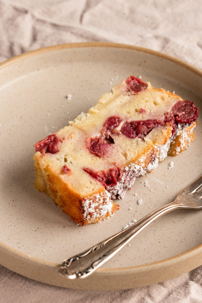 Ein Teller mit einem Stück Armer Ritter Kuchen mit Kirschen.