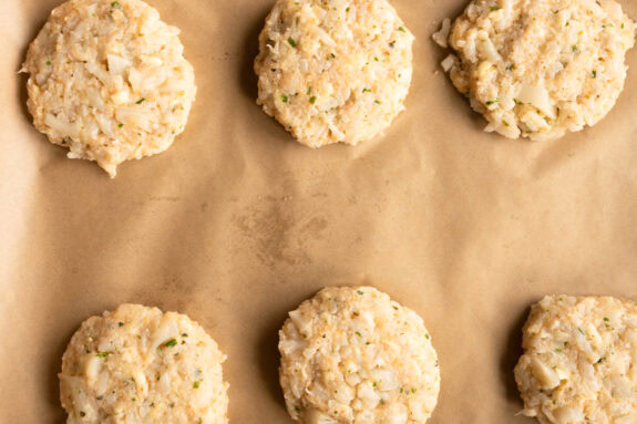 Die rohen Blumenkohl Taler liegen auf einem Backblech.