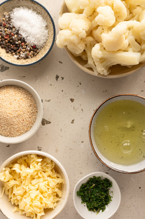 Die Zutaten für die Blumenkohl-Käse-Taler stehen auf dem Tisch.