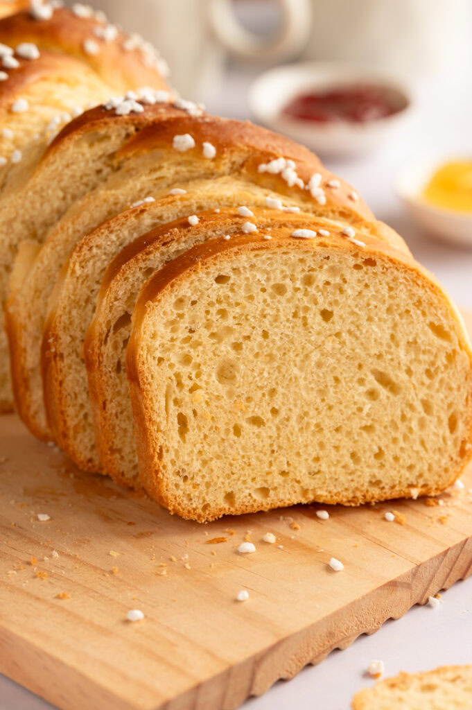 Eine angeschnittenes Brioche Brot liegt auf einem Brett.
