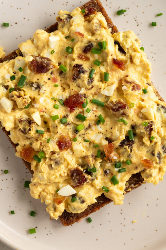 Ein Brot mit Curry-Dattel-Eiersalat liegt auf einem Teller.