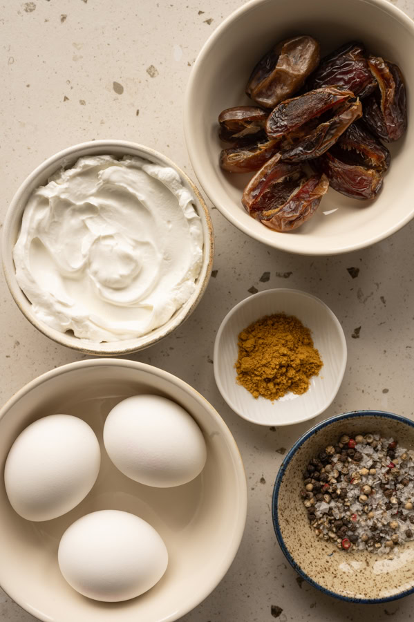Die Zutaten für den Eiersalat mit Curry und Datteln stehen auf einem Tisch.