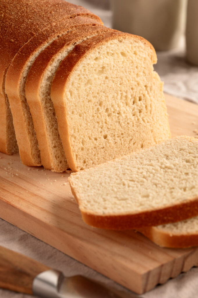 Das Milchbrot liegt auf einem Brettchen und ist in Scheiben geschnitten.