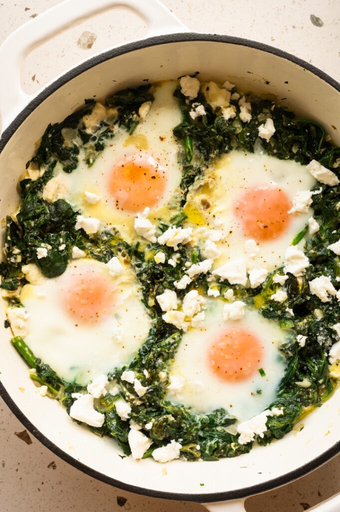 Eine Nahaufnahme der Spinatpfanne mit Feta und pochierten Eiern.