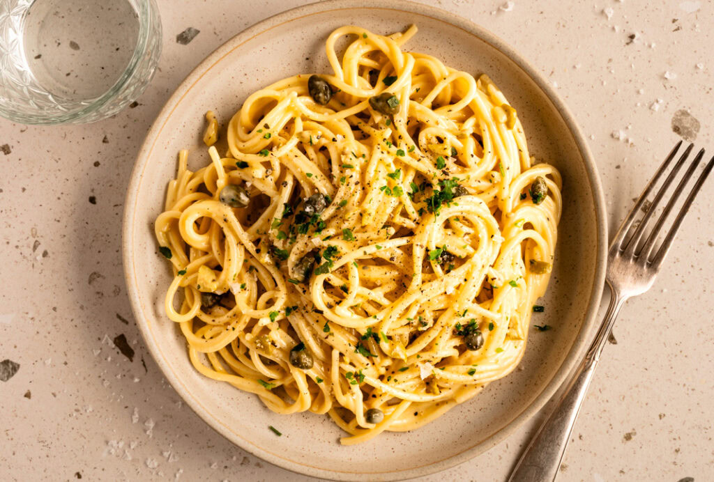 Ein Teller mit vegetarischer Spaghetti Carbonara ohne Tofu steht auf dem Tisch.