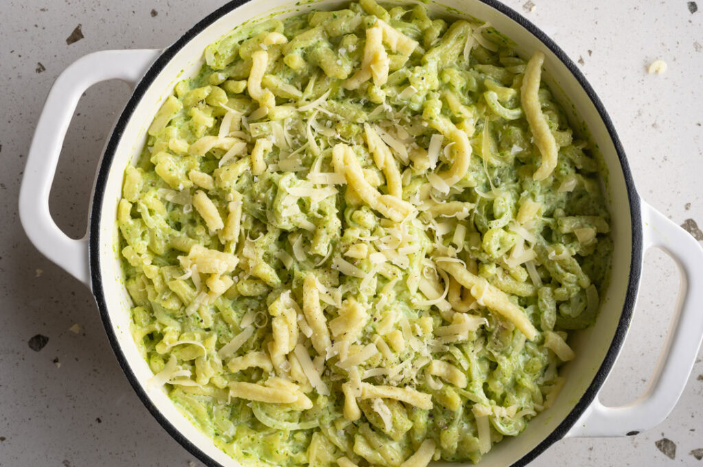 Eine Pfanne mit Bärlauch-Käsespätzle steht auf einem Tisch.