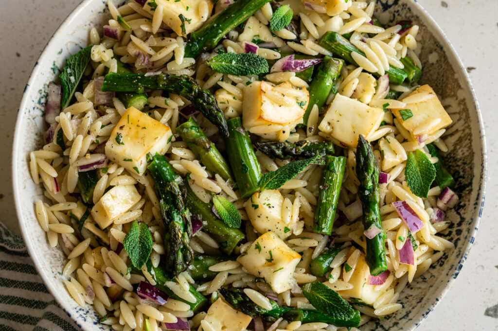 Eine Nahaufnahme einer Schüssel mit Orzo Spargel Salat.