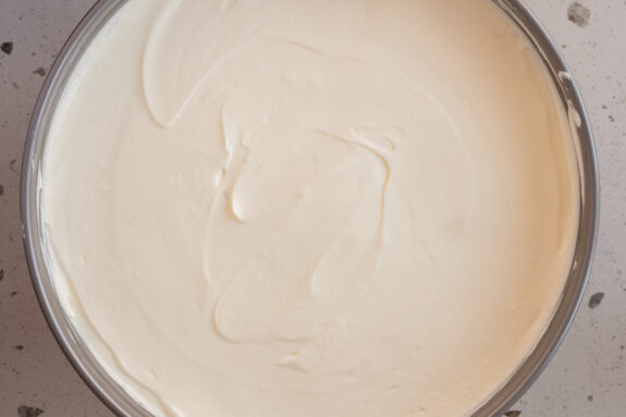 Die Käsekuchen-Creme ist auf dem Rhabarber verteilt.