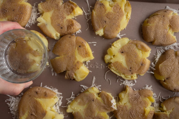 Eine Person drückt die Kartoffeln platt.