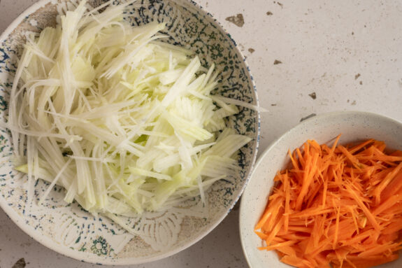 Der klein geschnittene Kohlrabi und die Karotten stehen auf dem Tisch.