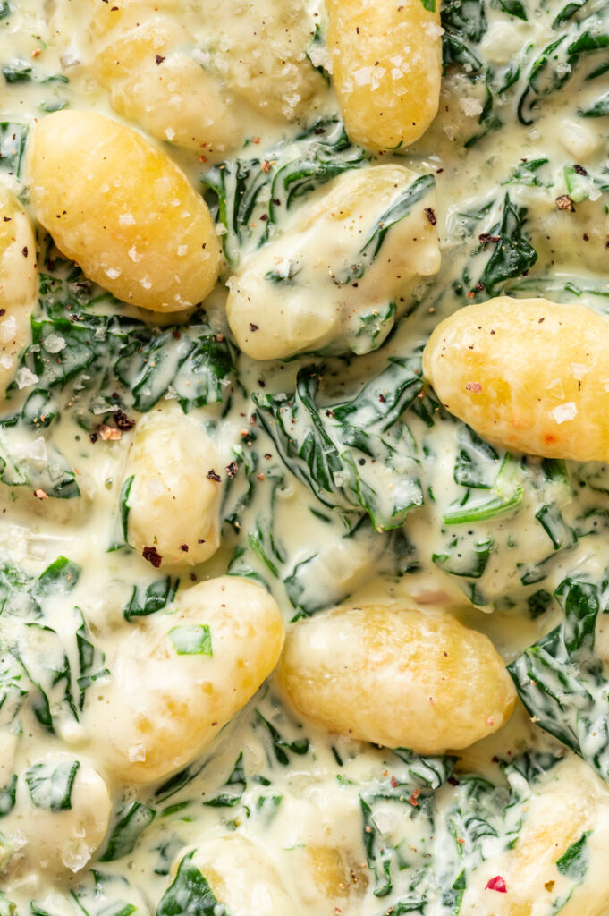 Eine Nahaufnahme der Gnocchi mit Spinat.