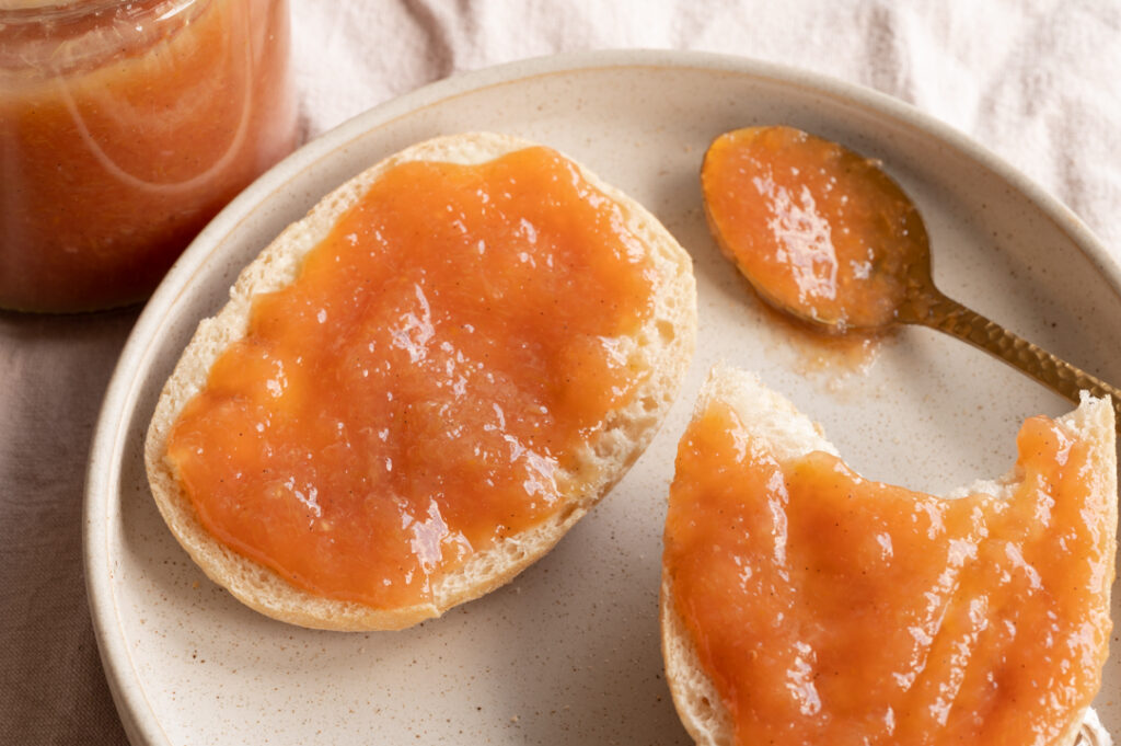 Ein Teller mit einem Brötchen mit selbst gemachter Rhabarber Marmelade.