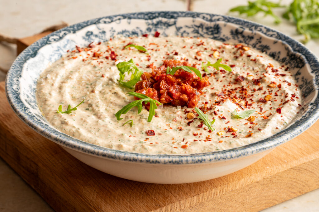 Eine Schüssel mit selbst gemachtem Rucola Dip steht auf einem Tisch.