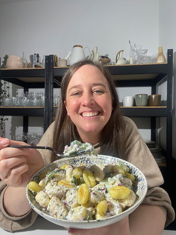 Eine Frau isst den knusprigen Gnocchi Salat