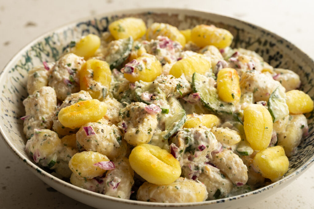 Eine Schüssel mit dem Crispy Gnocchi Salat steht auf einem Tisch.