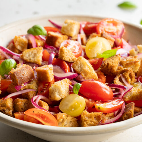 Ein Teller mit italienischem Brotsalat mit Tomaten steht auf einem Tisch.