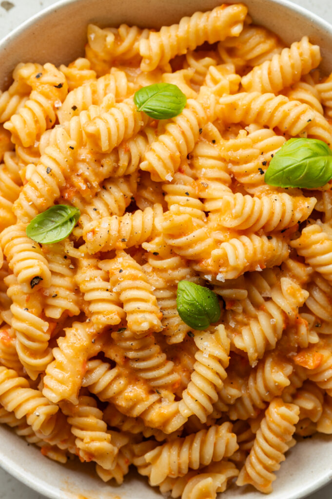 Ein Teller mit cremiger Paprika-Pasta steht auf dem Tisch.