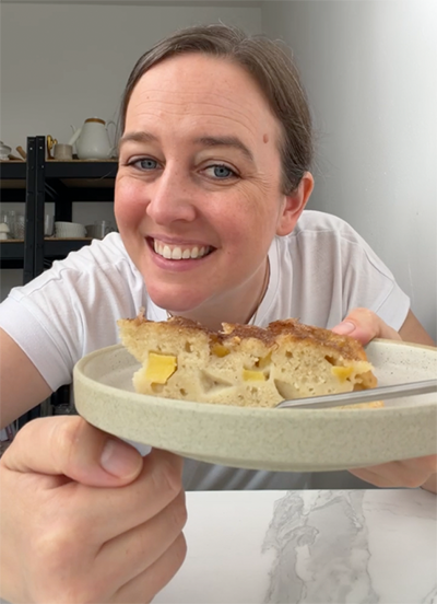 Ich esse ein Stück Apfelkuchen mit Joghurt.