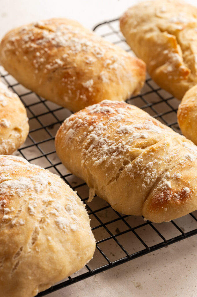 Die rustikalen Brötchen liegen auf einem Gitter.