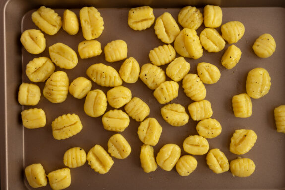 Die Gnocchi liegen auf einem Backblech.