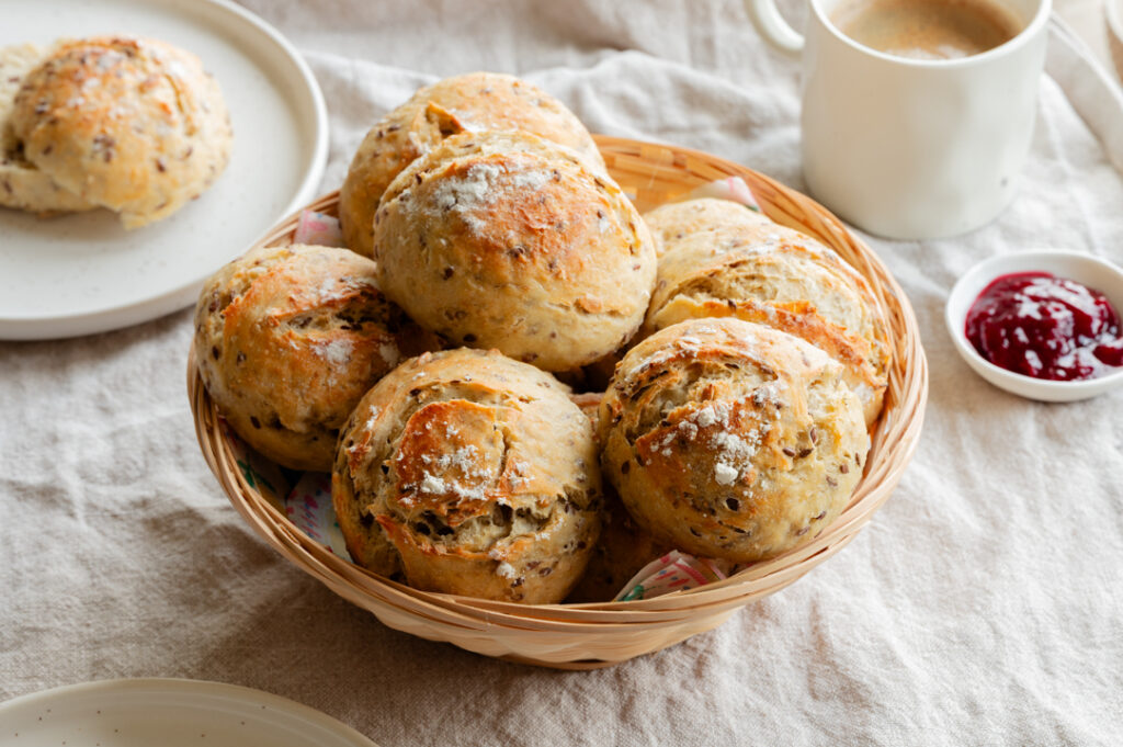 Ein Brotkörbchen mit Quark-Dinkel-Brötchen steht auf dem Tisch.