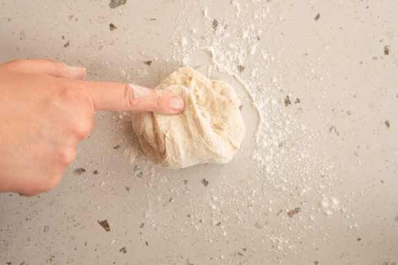 Eine Person formt die Brötchen.