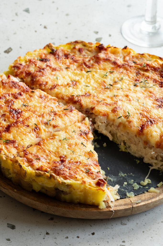 Der angeschnittene Zwiebelkuchen steht auf dem Tisch.