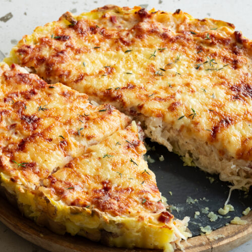 Ein vegetarischer Zwiebelkuchen mit Kartoffelboden aus der Tarteform.