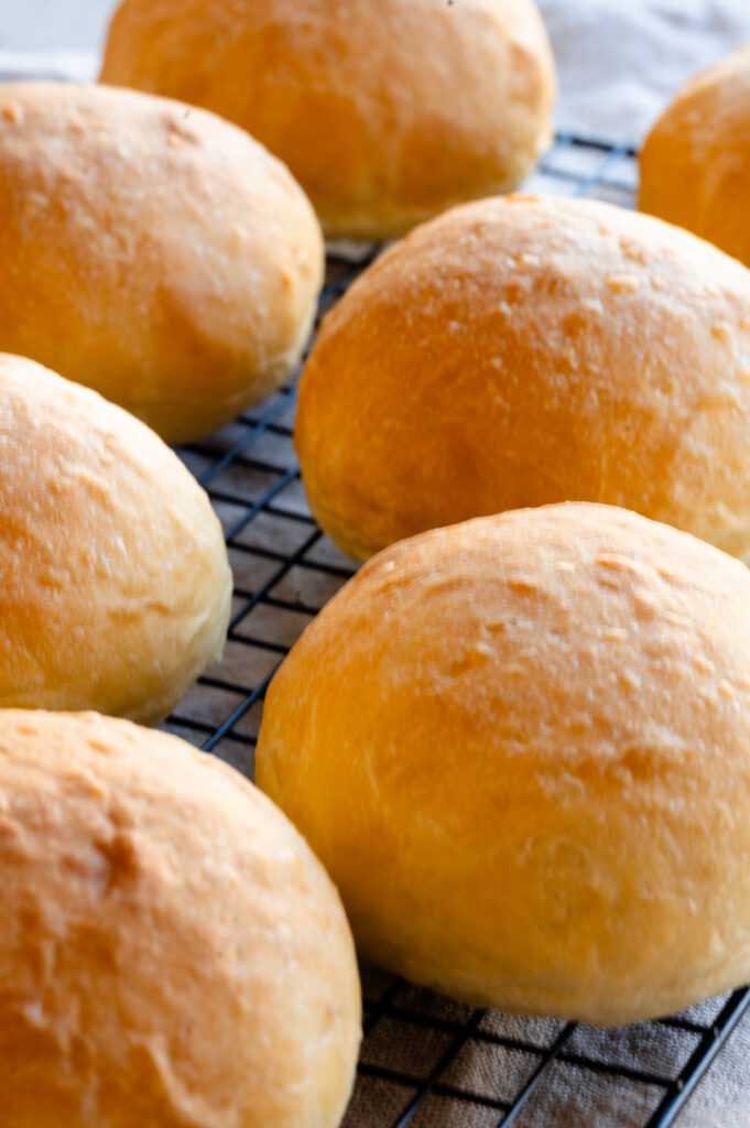 Die Brioche Burger Buns ohne Ei liegen auf einem Gitter.
