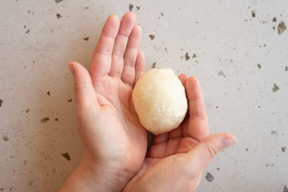 Eine Person formt die Burger Buns.