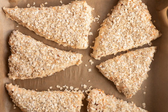 Die Brötchen liegen auf einem Backblech mit Backpapier.