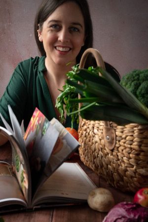 Eine Frau sitzt an einem Tisch und blättert durch ein Buch.